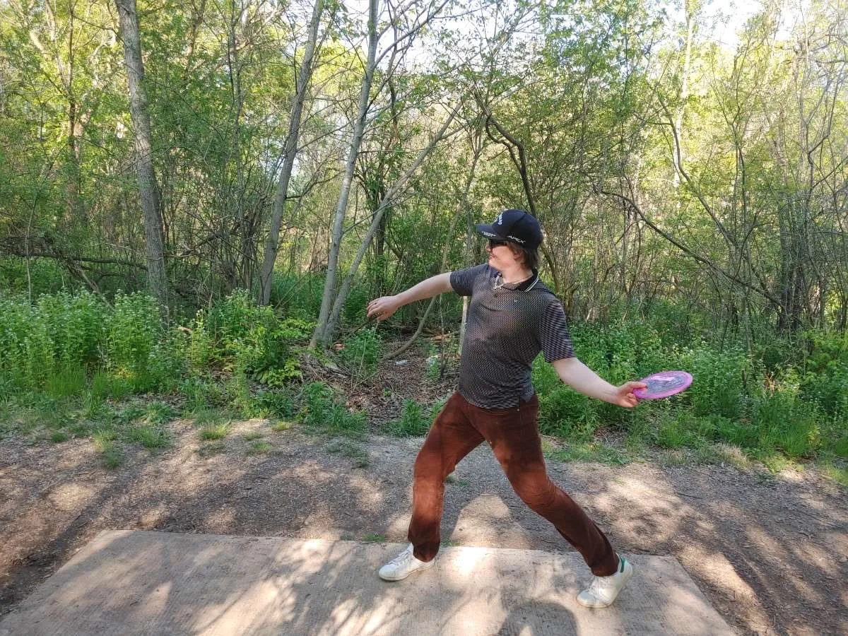 Michael throwing a frisbee in frisbee golf.